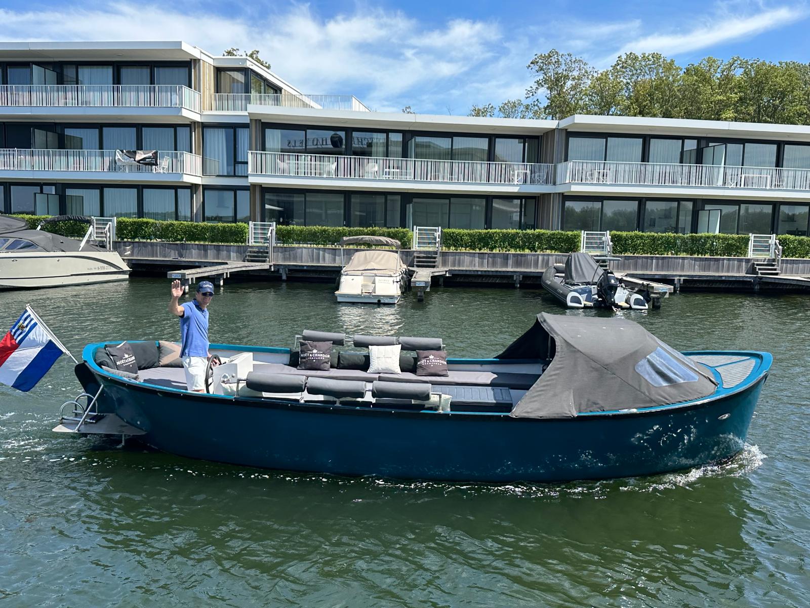 Skipper winkt von der Sloep vor dem Fletcher Hotel Veerse Meer